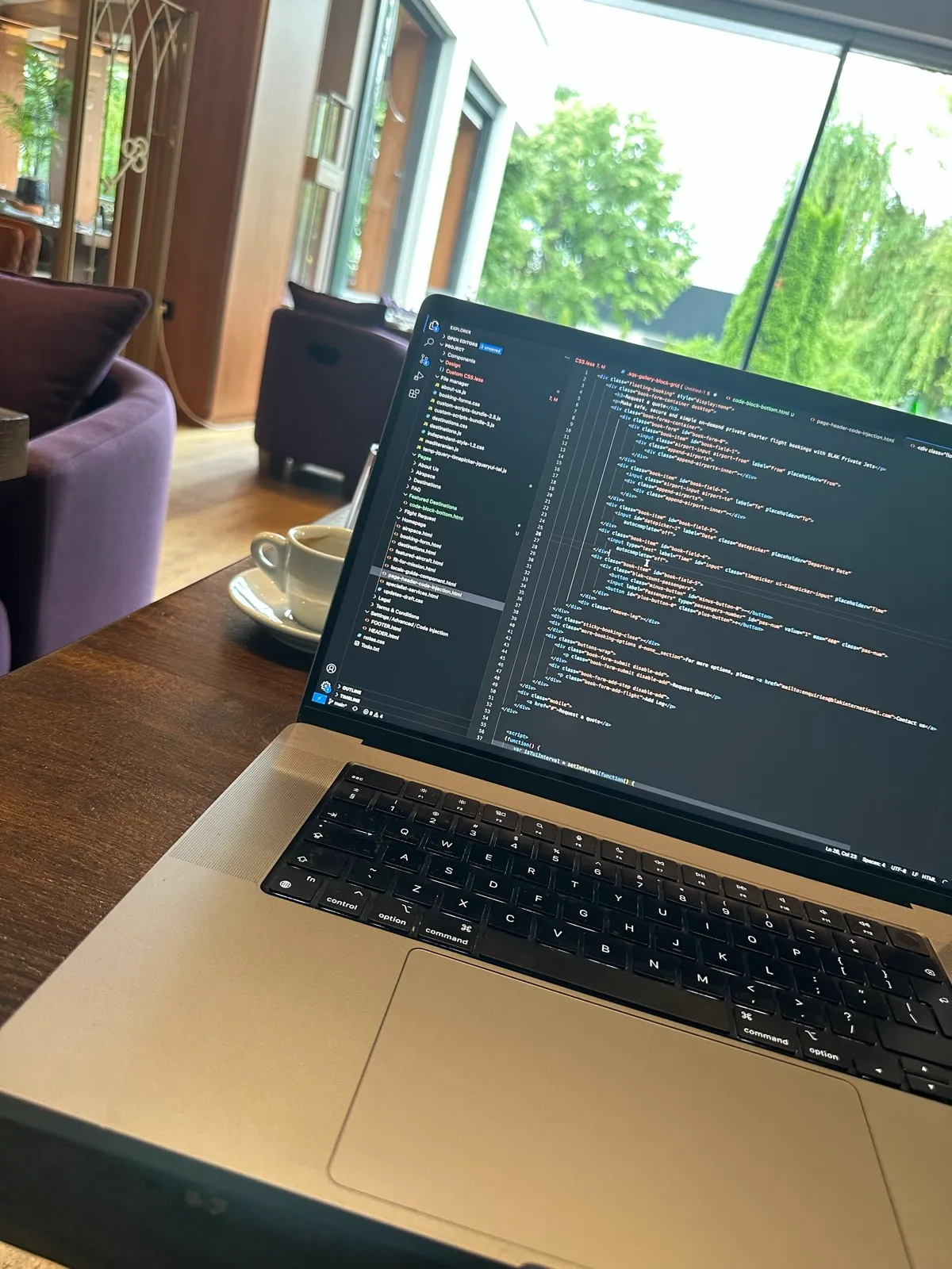 The flight request form code open in a code editor on a MacBook, with a coffee on the table